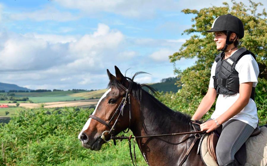 Happy rider on horseback on summer camp in Ireland.